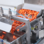 Bulk vegetables being weighed and filled into a packaging machine